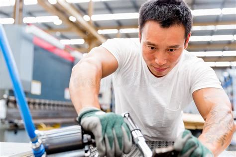 Asian Worker In Production Plant On The Factory Floor Stock Photo