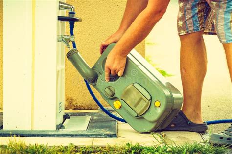 Man Emptying Caravan Tank Toilet Cassette In Dump Station Stock Photo