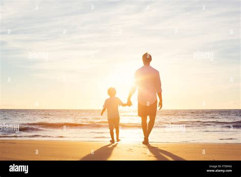 Father And Son Walking Together On The Beach At Sunset Fatherhood