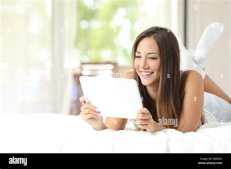 Happy Girl Watching Videos In A Tablet Lying On The Bed At Home Stock