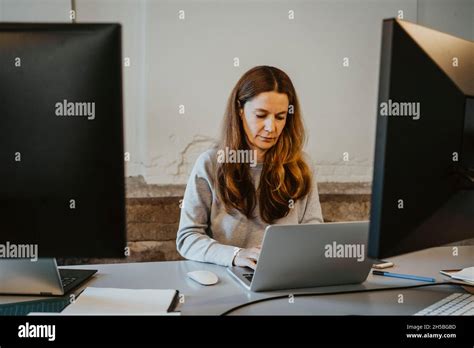 Mature Female Programmer Working On Laptop In Office Stock Photo Alamy