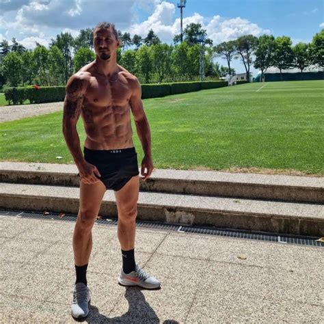 A Shirtless Man Standing In Front Of Some Steps With His Hands On His Hips