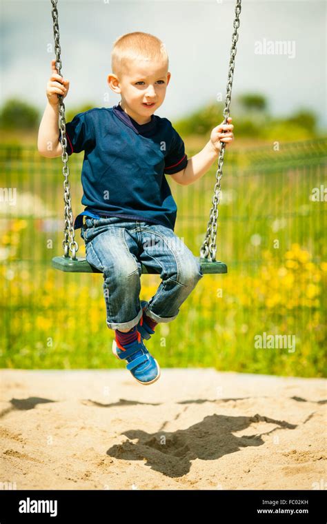 Little Blonde Boy Child Having Fun On A Swing Outdoor Stock Photo Alamy