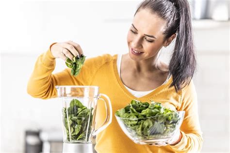 Premium Photo Smiling Woman Making Spinach Smoothie Putting Leaves In