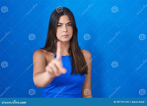 Hispanic Woman Standing Over Blue Background Pointing With Finger Up And Angry Expression