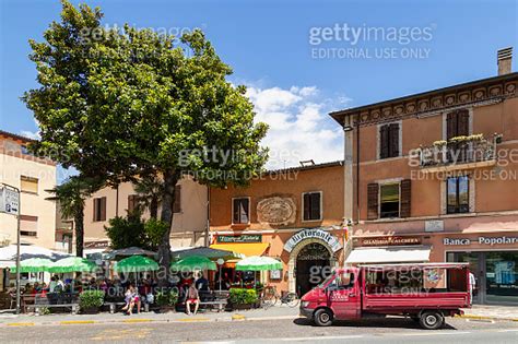 People Enjoy The Terrace In The Town Of Toscolano Maderno On Lake Garda