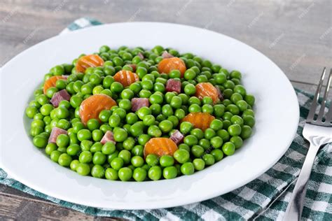 Ervilhas Verdes Com Presunto Serrano E Cenoura Na Mesa De Madeira Foto Grátis