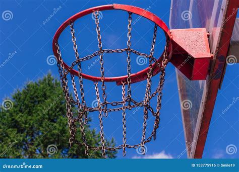 Outdoor Basketball Ring In Front Of Green Trees Background Stock Photo