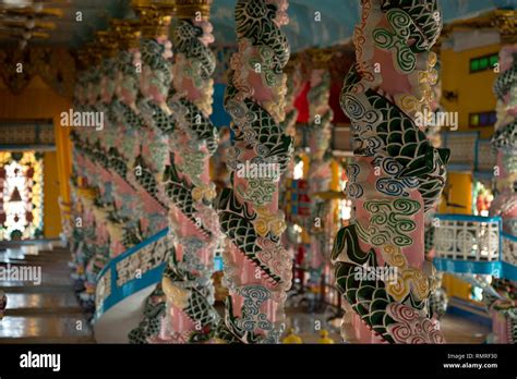 Cao Dai Temple interior, with colourful decorated columns with dragon ...