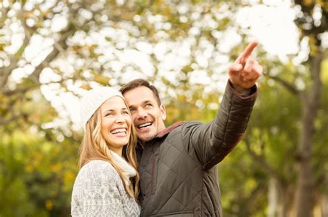 Retrato de sonriente joven pareja señalando algo Foto Premium