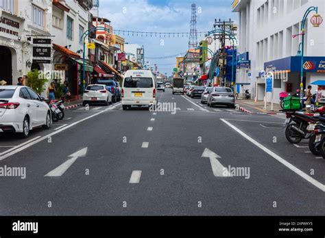 View Of Phuket Downtown In Thailand With Motorbikes And Cars On The