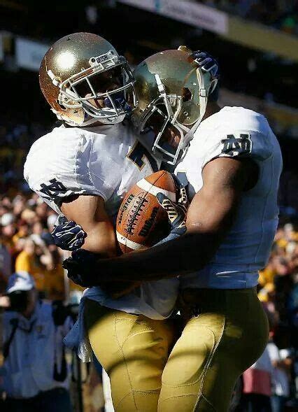 Two Football Players Hugging Each Other On The Field