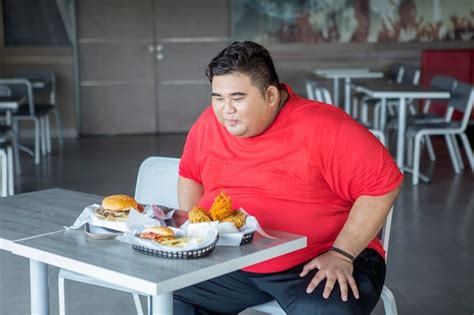 Premium Photo | Overweight man ready to eat fast food in cafe