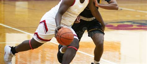 Basketball Player Driving On His Opponent To The Basket Stock Image