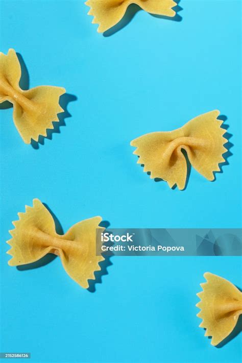 Uncooked Bow Tie Pasta Farfalle Scattered On A Blue Background In A