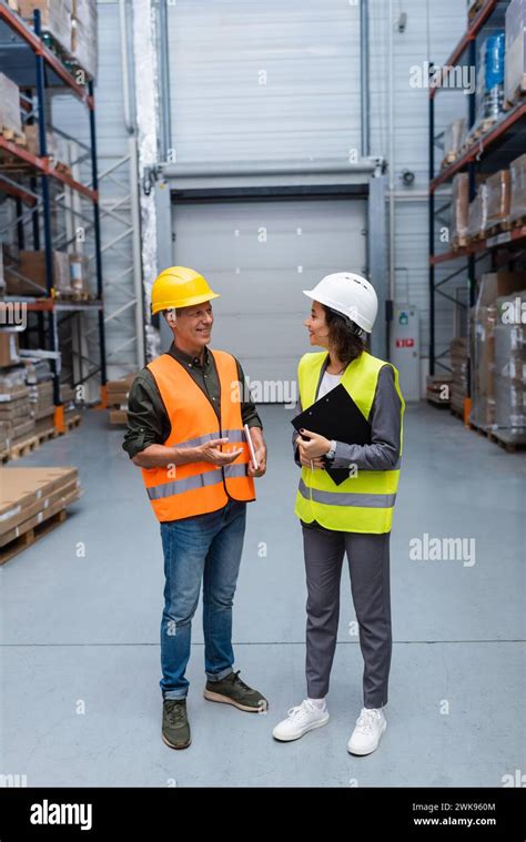 Warehouse Employees Having A Friendly Chat Happy Man And Woman In Hard