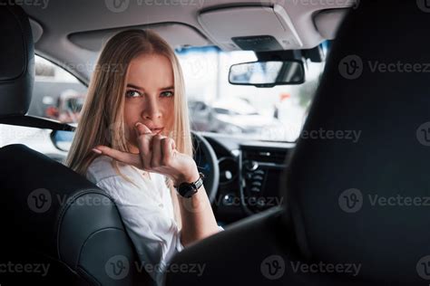 se retourna vers les caméramans à l arrière belle fille blonde assise dans la nouvelle voiture