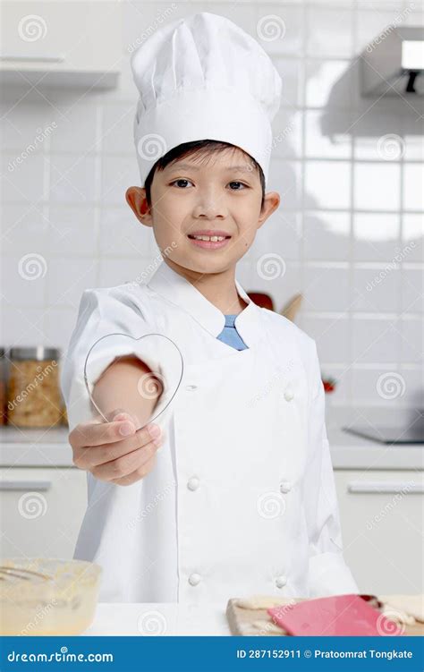 Portrait Of Happy Smiling Asian Boy In White Chef Uniform With Hat