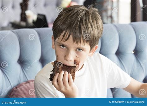 Boy Is Eating A Large Piece Of Cake In His Hands Stock Image Image Of