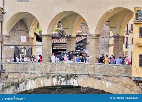 Tourists On The Ponte Vecchio Bridge Over Arno River In Florence