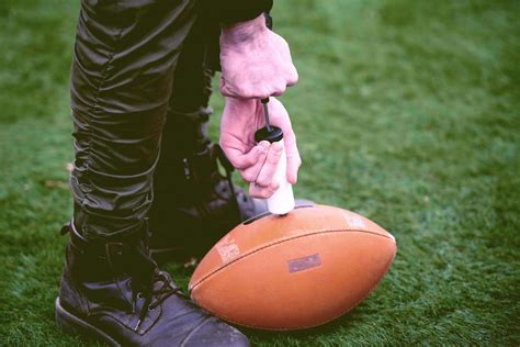 man pumping air into american football ball 12711752 Stock Photo at ...