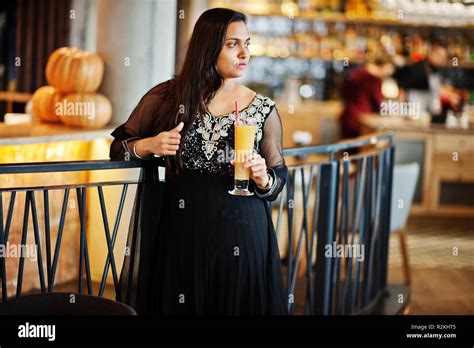Pretty Indian Girl In Black Saree Dress Posed At Restaurant With Orange