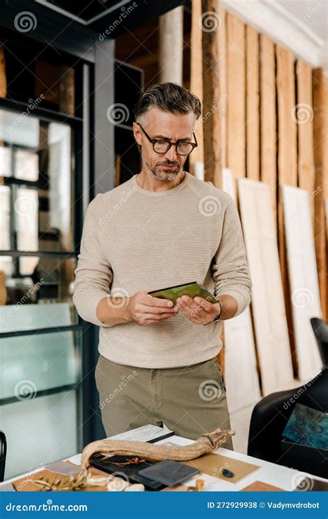 Mature Man In Eyeglasses Examining Samples While Working At Office