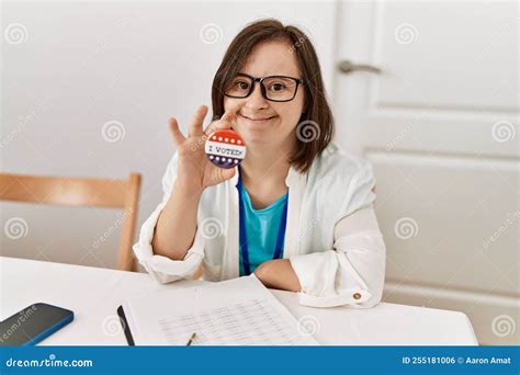 Brunette Woman With Down Syndrome Smiling Holding Vote Badge At