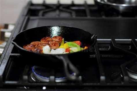 Saucisse Faisant Cuire Sur Le Fourneau Dans Une Po Le De Fonte Image