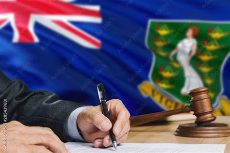 Judge Writing On Paper In Courtroom With British Virgin Islands Flag