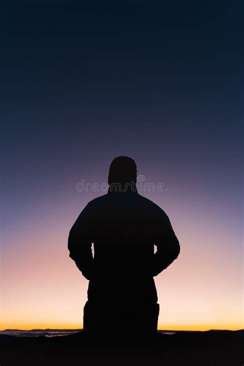 Toma Vertical De Una Silueta De Un Hombre De Pie Al Atardecer Foto De