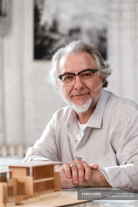 Professional Mature Architect In Eyeglasses Sitting At Workplace And