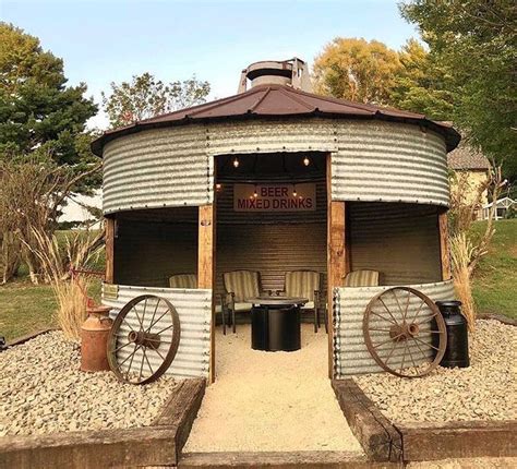 a large metal barrel sitting in the middle of a yard next to a table ...