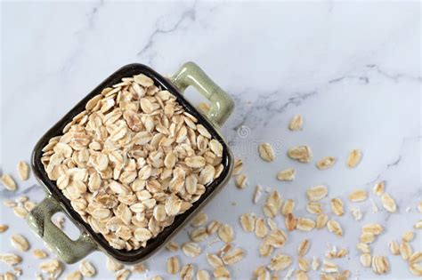 Oatmeal Flakes Rolled Oats In A Bowl Isolated On White Marble