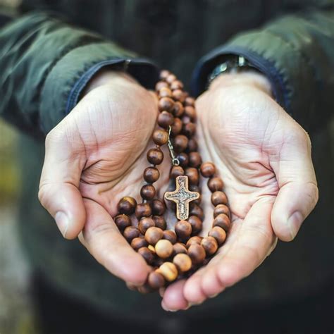 Premium Photo Hand Holding Wooden Rosary Beads