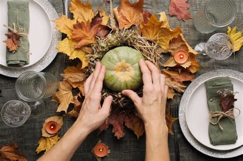 Ajuste de la mesa de otoño las manos hacen un arreglo de otoño con