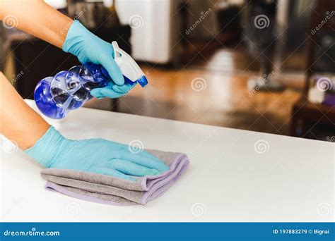 Sanitizing Surfaces Cleaning Kitchen Table With Disinfectant Spray