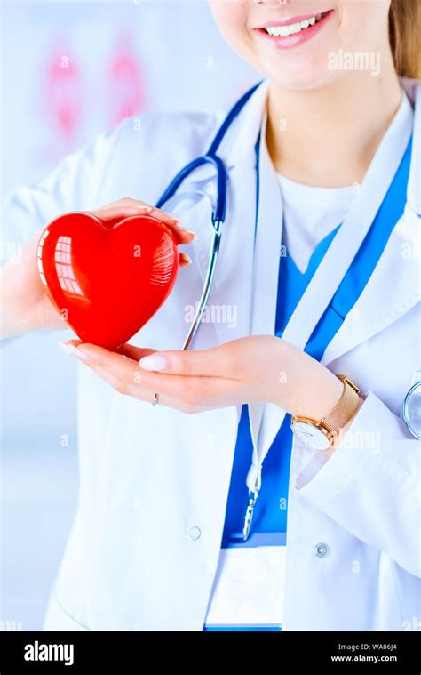 Female Doctor With Stethoscope Holding Heart On Light Background