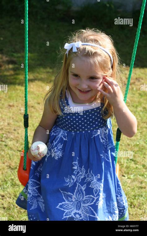 Petite Fille Blonde Yeux Marron Enfant Kid Swing Oscillante Eating Ice Cream Cone Sur Une