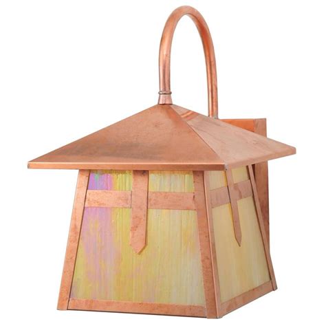 A Small Copper Colored Lantern Hanging From The Ceiling With An Orange