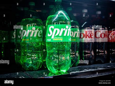 Las botellas de Sprite en su plástico verde se ven en un estante de