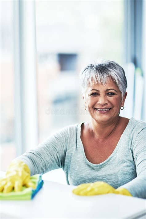 Mature Woman Cloth And Cleaning Table In Home Portrait And Smile For