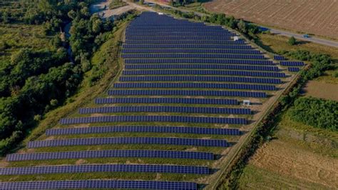 Vista aérea superior na usina de energia solar em campo verde em dia