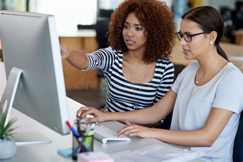 Working Closely Together On The Project Two Female Coworkers Working