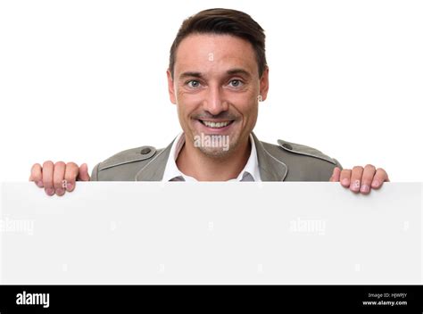 Cheerful Man Standing Behind A Blank Billboard Isolated On White