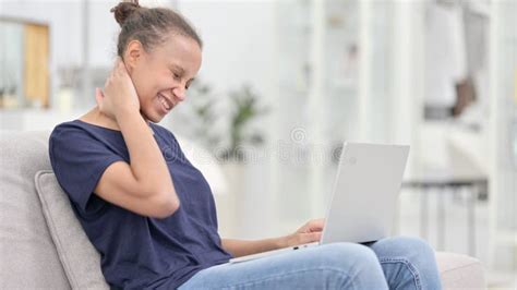 Tired African Woman With Laptop Having Neck Pain At Home Stock Photo