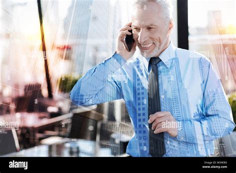 Emotional Mature Man Smiling While Talking On The Phone Stock Photo Alamy