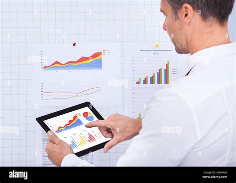 Mature Businessman Analyzing Graph On Digital Tablet Stock Photo Alamy