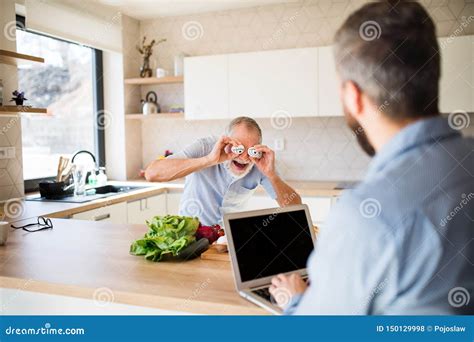 Adult Hipster Son And Senior Father Indoors In Kitchen At Home Having