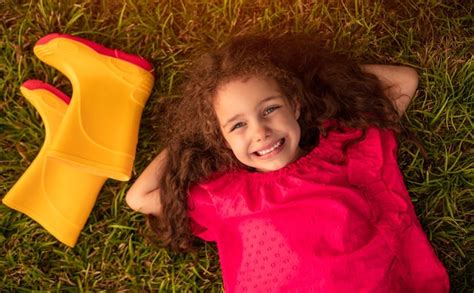 Niño feliz descansando cerca de botas Foto Premium